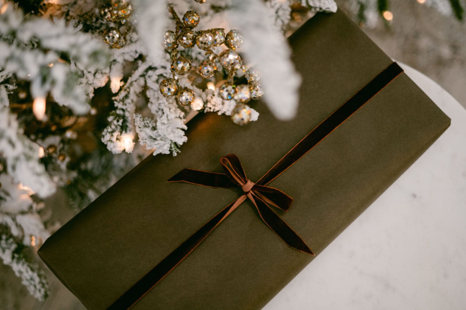 Gift box under a decorated Christmas tree.